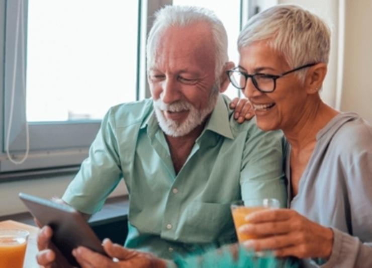 Man and woman sitting in their home, talking and enjoying a cup of coffee